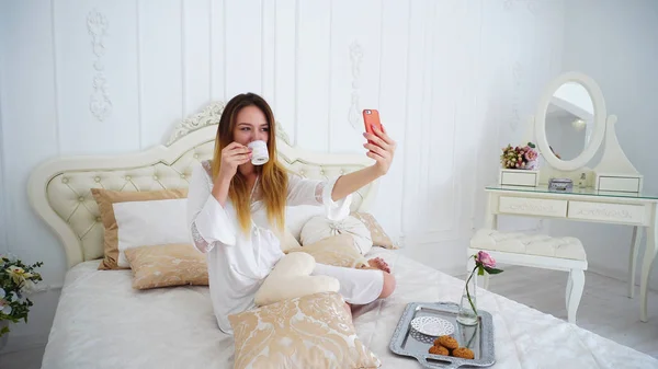 Chica de aspecto atractivo hace selfie en frente de la cámara del teléfono inteligente , — Foto de Stock