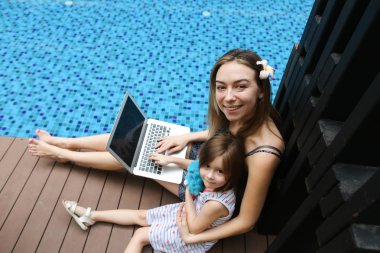 Yakın çekim kadın anne, kızı ve arka plan üstünde laptop 