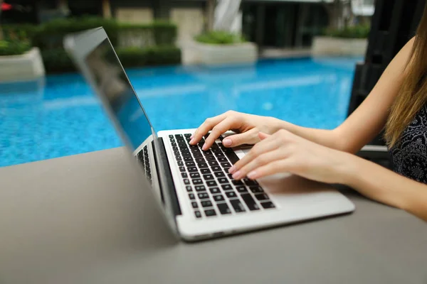 Fechar as mãos mulher pressionando teclado no laptop dia ensolarado nadando — Fotografia de Stock