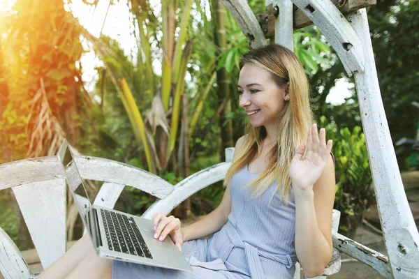 Mujer rubia utiliza el ordenador portátil para el trabajo en el día soleado, fondo de palmas verdes sol en Tailandia, viajes Phuket — Foto de Stock