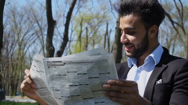 Gazete araç satış hakkında reklamlar beyefendi okur.