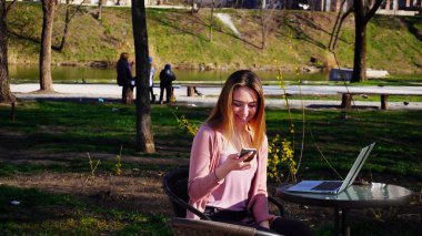Güzel kızla yakın çekim yüz tablo ile bahar Park'ta dinlenme