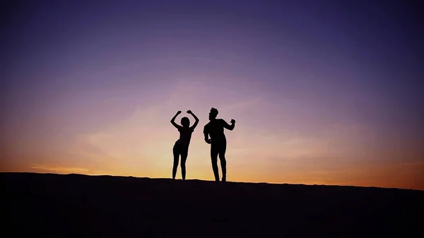 Happy loving, guy and girl dancing on top of sandy hill in midd — стоковое фото