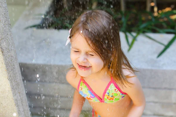 Cerca de gotas de retrato de agua caen sobre la niña en traje de baño — Foto de Stock