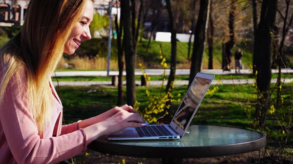 Hermosa persona femenina charlando con amigos por tableta en el parque . — Foto de Stock