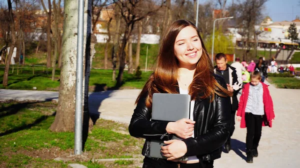 Hübsche Studentin spaziert mit Laptop und genießt gutes Wetter — Stockfoto