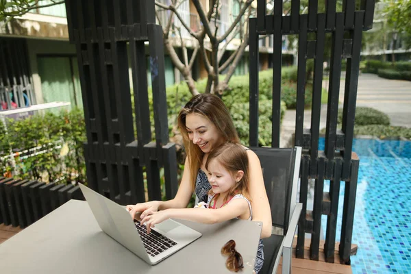 mother and daughter use laptop for online shopping on background