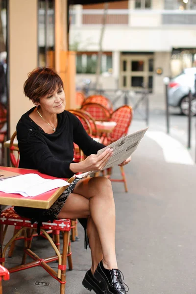 Mujer de mediana edad discute nueva edición del periódico . — Foto de Stock