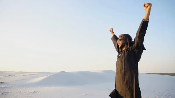 Щасливий Емірат чоловік гуляє по околицях пустелі з посмішкою на обличчі — стокове фото