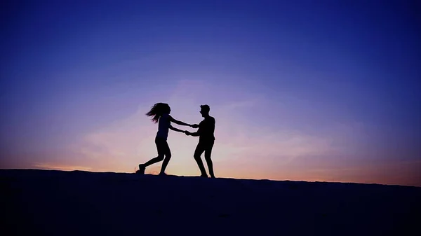 Aşıklar birbirlerine doğru koşmak ve çölde kum tepe üzerinde girdap — Stok fotoğraf