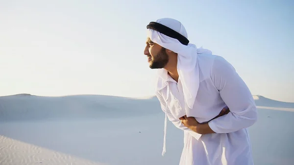 Young male emirate suffers from severe pains in abdomen, standin — Stock Photo, Image