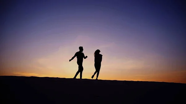 Vrouwelijke en mannelijke hand in hand samen tot top van zandstrand heuvel — Stockfoto