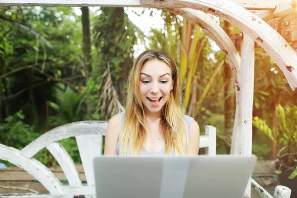 Mujer sorprendida utiliza el ordenador portátil haciendo trabajo en línea en el día soleado, fondo de palmas verdes sol en Tailandia, viajes Phuket — Foto de Stock