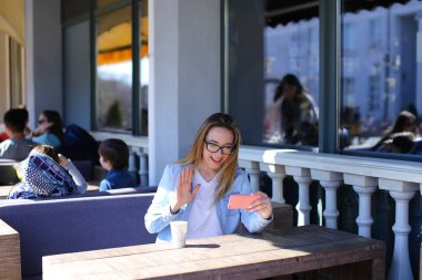Kız smartphone kafede görüntülü arama yapma.