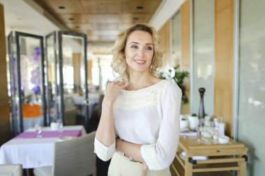 Sofra arka plan ile restoranda duran güzel kadın.