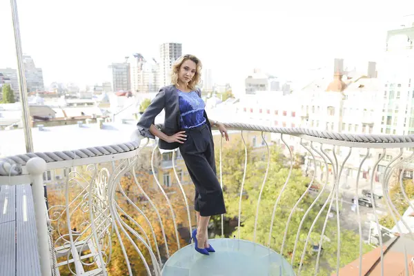 Hermosa mujer de negocios de pie en el balcón con fondo rascacielos . — Foto de Stock