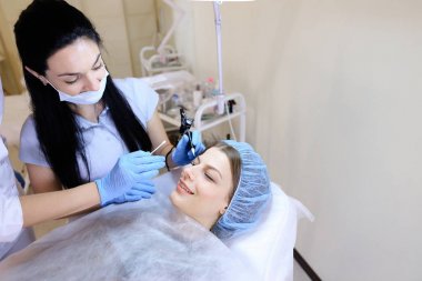 Kadın için dövme yordam tarafından makinesi güzellik uzmanı.