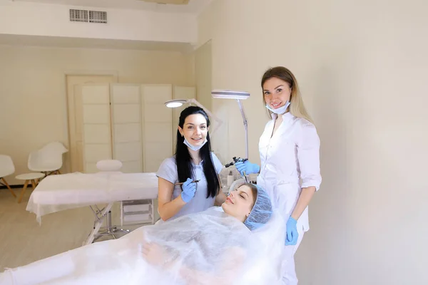 Улыбающаяся женщина получает постоянный грим в косметологическом кабинете дерматолога . — стоковое фото