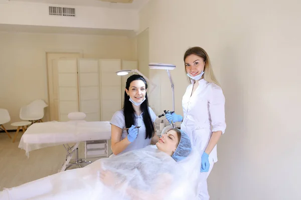 Smiling woman getting permanent makeup at cosmetology cabinet by dermatologist. — Stock Photo, Image