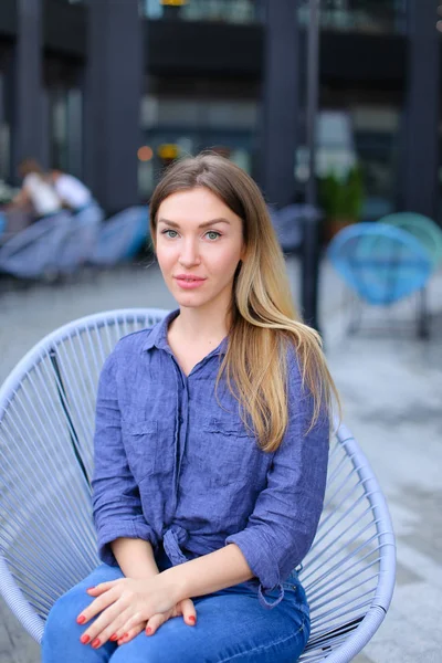 아름 다운 여성 사람 밖에 서 카페에 앉아 파란 셔츠를 입고. — 스톡 사진
