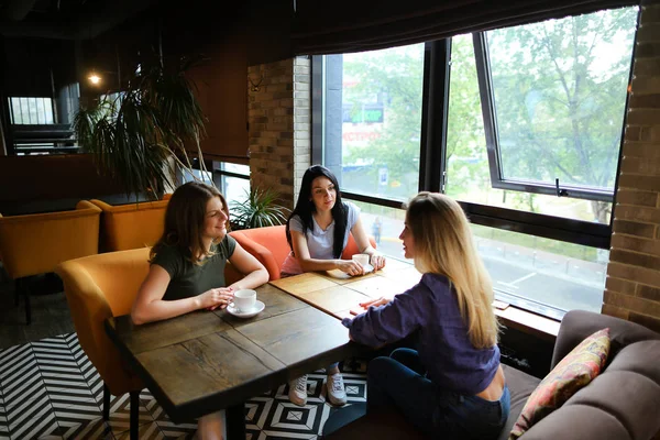 Frauen sitzen im Restaurant, reden und trinken Kaffee. — Stockfoto