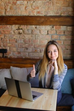 Masanın defter ile ve bir cappuccino.v tutan kız gülümseyerek