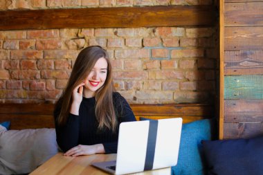 Genç güzel kız erkek arkadaşıyla laptop yanında sohbet.