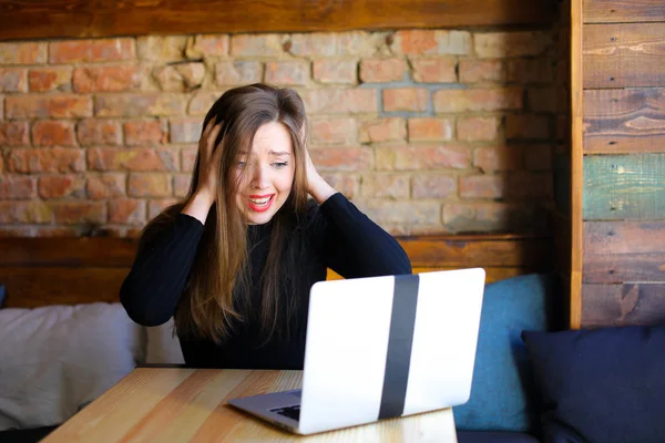 Disgruntled female person using laptop and sitting at cafe. — Stock Photo, Image
