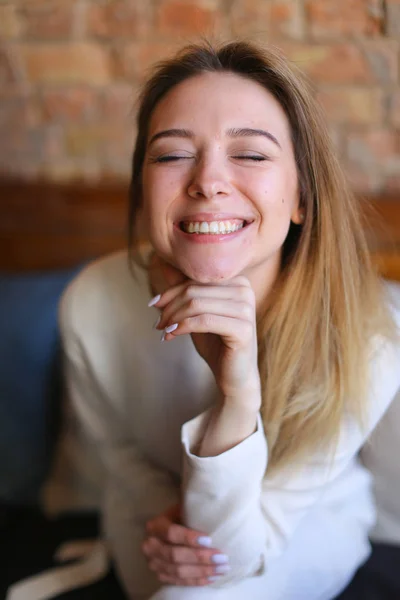 Señora sentada en la silla cerca de la mesa de madera y smillind . — Foto de Stock