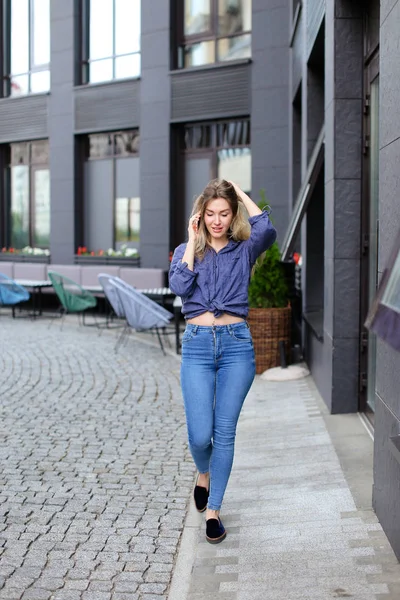 Mujer elegante hablando por teléfono inteligente en la ciudad, usando jeans . — Foto de Stock