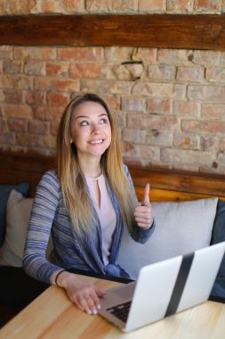 Kahve Tablo yakınındaki ahşap sandalye üzerinde oturan ve bir fotoğraf için poz kız.