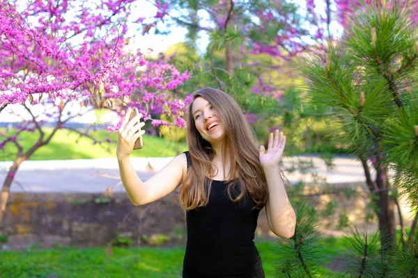 Kvinnliga person att göra selfie av smartphone med spring blossom bakgrund. — Stockfoto