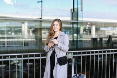 Sohbet ve smartphone valiz ve Havaalanı yakınında tarama beyaz kadın kişi.