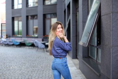 Şık Bayan yanında smartphone City, konuşurken kot giyen.