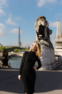 Eyfel Kulesi arka planda, aslan heykeli yakın duran güzel kadın Paris.