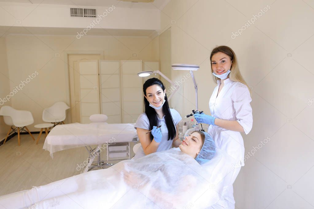 Pretty woman getting permanent makeup at cosmetology cabinet by dermatologist.