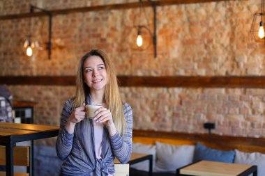 Memnun kız masanın sıradışı iç rahat kafe kapuçino fincan ile.