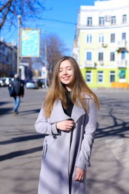 Açık havada geziniyor ve siyah elbise ile gri ceket giyen Amerikalı kız.