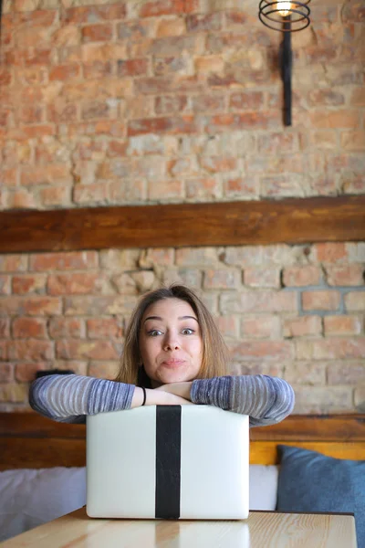 金凯悦妇女在咖啡馆享受笔记本电脑和制作面孔. — 图库照片