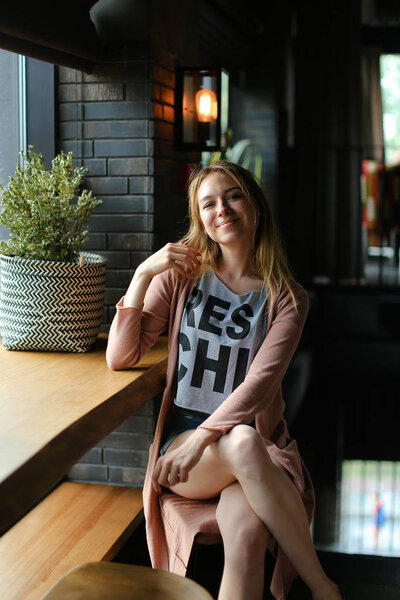 Stylish caucasian woman sitting at cafe near table.