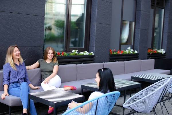 Pozytywne koleżanki rozmawia w kawiarni i siedzi na kanapie. — Zdjęcie stockowe