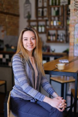 Memnun kız masanın sıradışı iç rahat kafe kapuçino fincan ile.