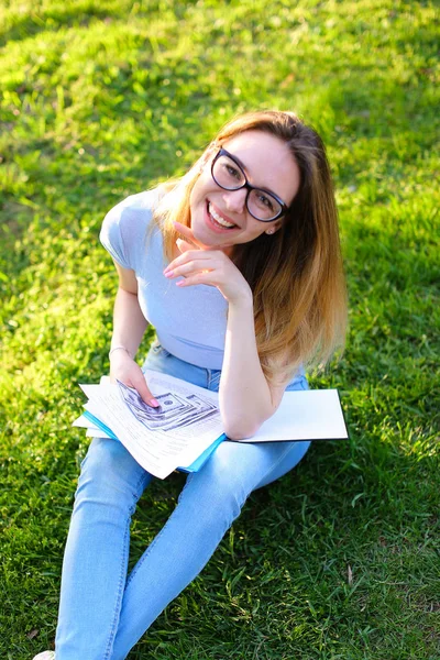 Libero professionista di successo seduto su erba verde con documenti nel parco e mantenere i soldi . — Foto Stock