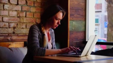 Kadın yazarı kafede dizüstü tarafından makale yazma.