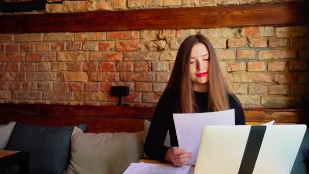 Estaticista trabalhando com documentos e laptop no café . — Vídeo de Stock