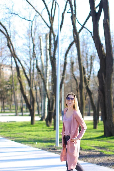 Beautiful girl walking in park and wearing long sweater. — Stock Photo, Image