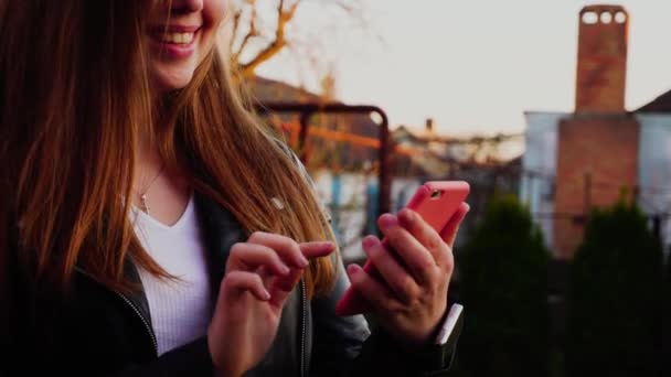 Meisje met close-up handen browsen door smartphone buiten. — Stockvideo