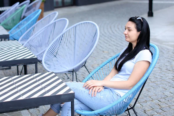 Morena mujer persona sentada en silla en la cafetería de la calle . — Foto de Stock