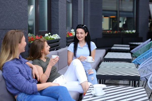 Lächelnde Freundinnen, die im Café lachen und tratschen, Kaffee trinken. — Stockfoto