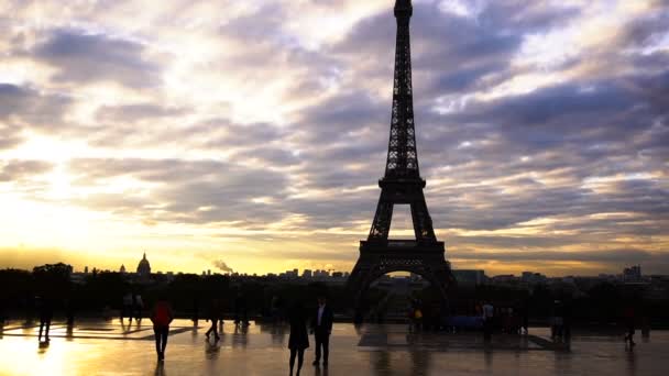 Passageiros caminhando perto da Torre Eiffel com fundo de sol . — Vídeo de Stock